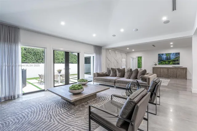 a living room with furniture a table and a large window
