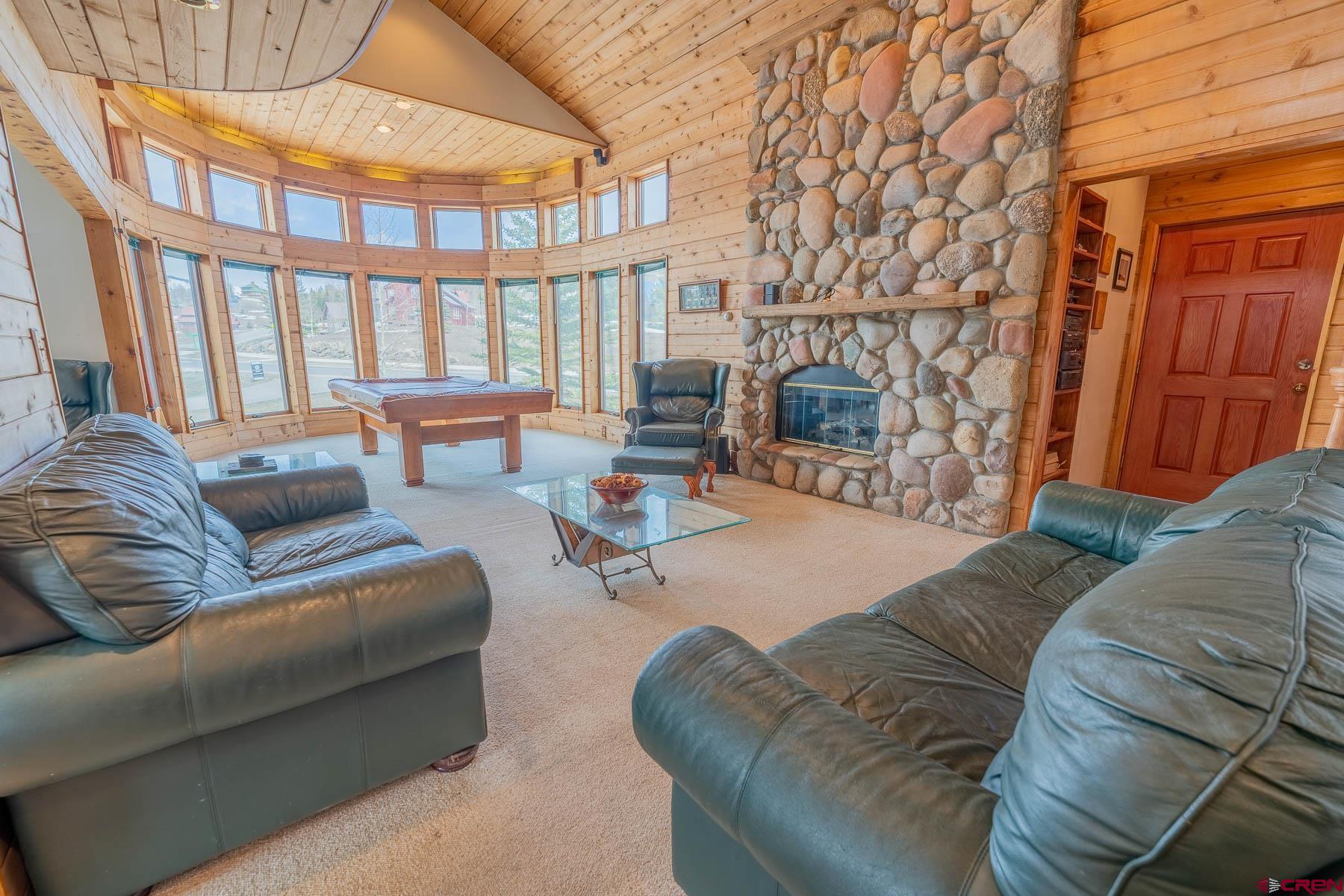 10 Arrowhead Circle Crested Butte, CO 81225 - Photo 5 of 33 a living room with furniture a fireplace and a floor to ceiling window