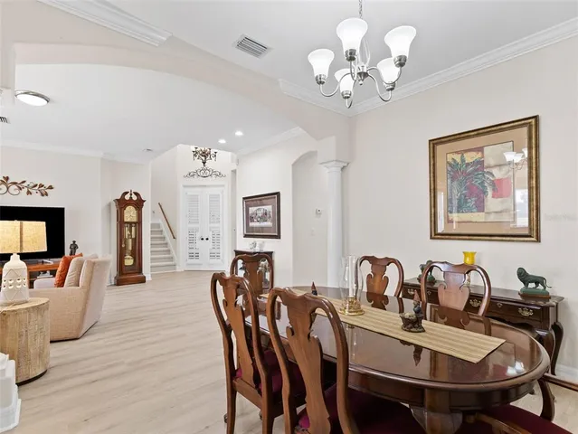a living room with furniture and a dining table with wooden floor