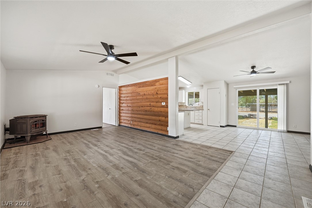 1531 West Harris Farm Road Pahrump, NV 89060 - Photo 17 of 37 An open-concept living space boasts varied flooring and a rustic wood accent wall, offering comfort and style.