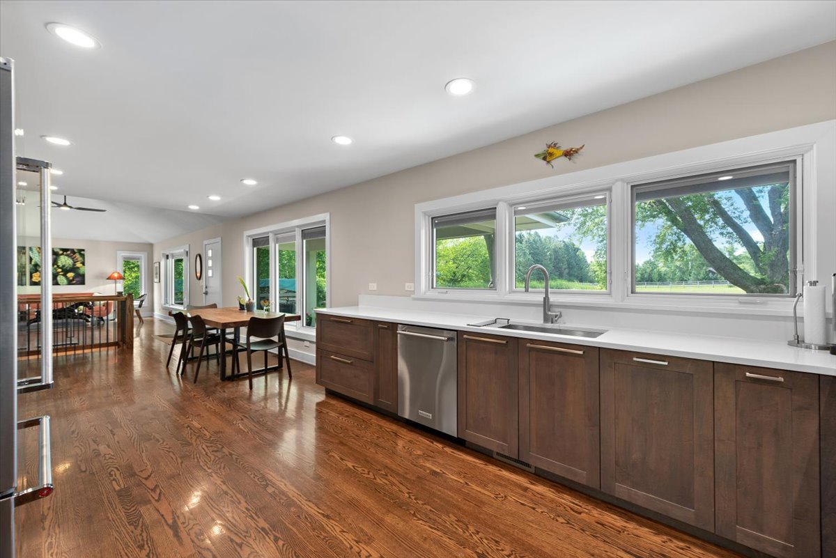 5908 Edgewood Road Crystal Lake, IL 60012 - Photo 10 of 60 a large dining hall with stainless steel appliances granite countertop a stove a sink a dining table and chairs with wooden floor