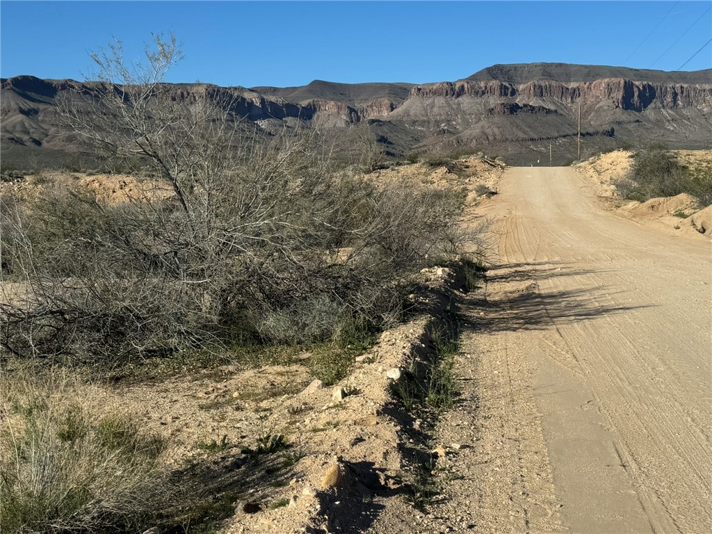 4332 West Sunset Road Yucca, AZ 86438 - Photo 2 of 7 a view of a dry yard with mountains in the background
