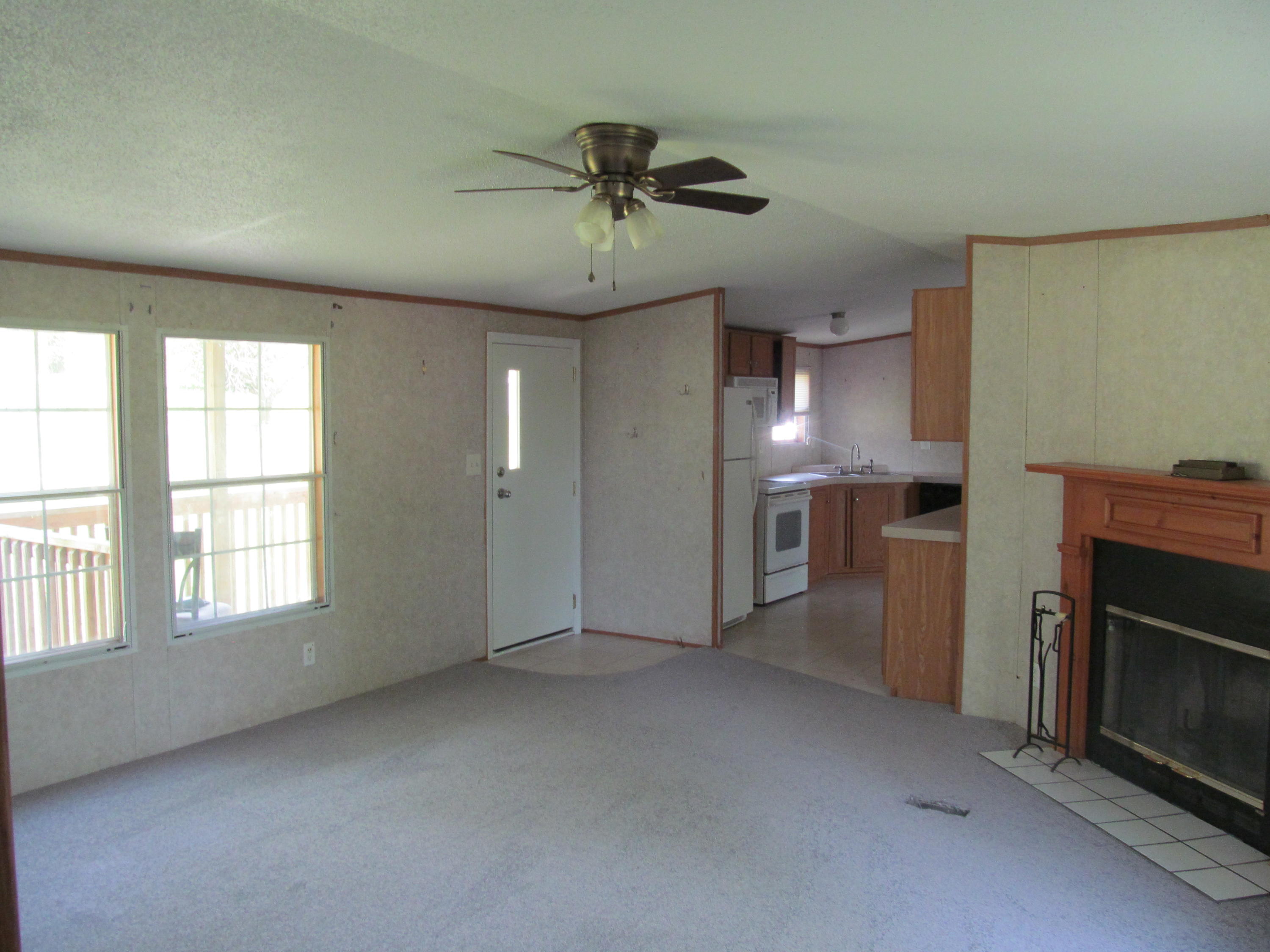 312 Piney Branch Road Blue Ridge, VA 24064 - Photo 3 of 21 an empty room with chandelier fan and windows