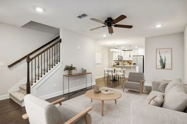 a living room with furniture and a view of kitchen