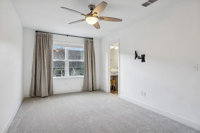 an empty room with closet and a ceiling fan