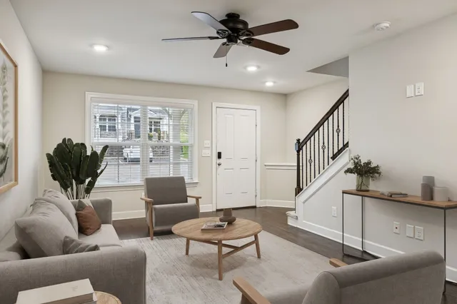 a living room with furniture ceiling fan and a window