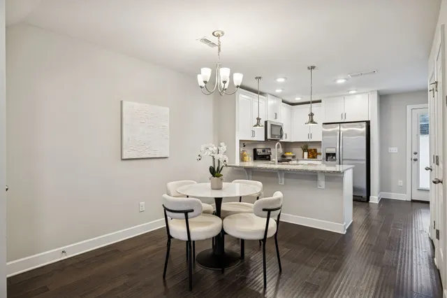 a view of a dining room with furniture a chandelier and wooden floor