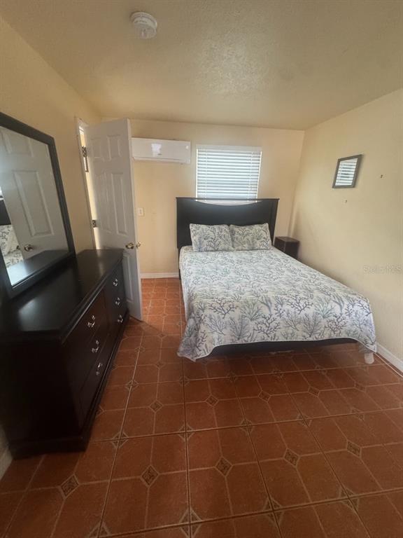 14715 Gulf Boulevard, Unit 2 Madeira Beach, FL 33708 - Photo 6 of 9 a bedroom with a bed and a mirror