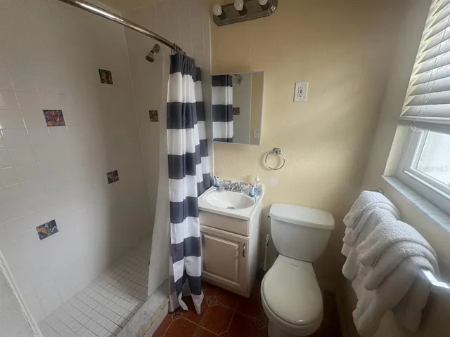 a white toilet sitting next to a bathroom sink and tub