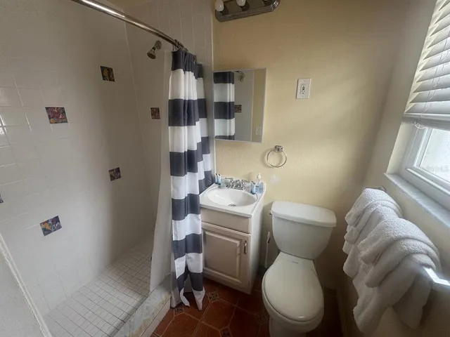 a white toilet sitting next to a bathroom sink and tub