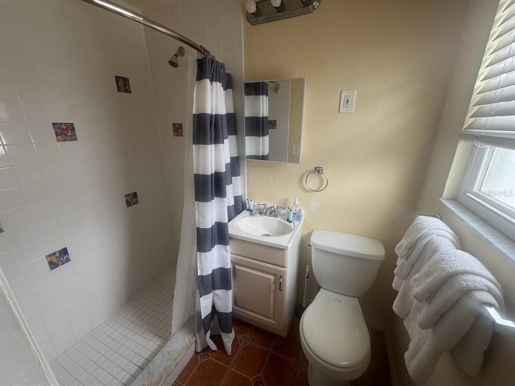 14715 Gulf Boulevard, Unit 2 Madeira Beach, FL 33708 - Photo 9 of 9 a white toilet sitting next to a bathroom sink and tub