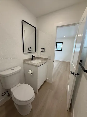 a bathroom with a toilet a sink and mirror
