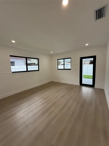 a view of a livingroom with wooden floor and window