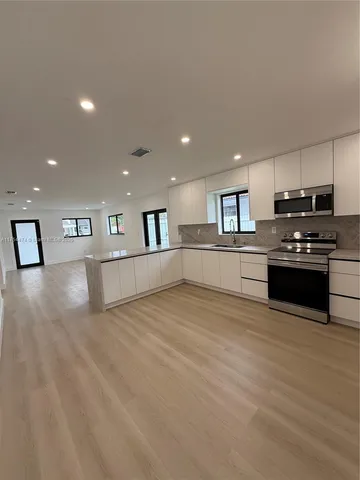 a view of kitchen with microwave and cabinets