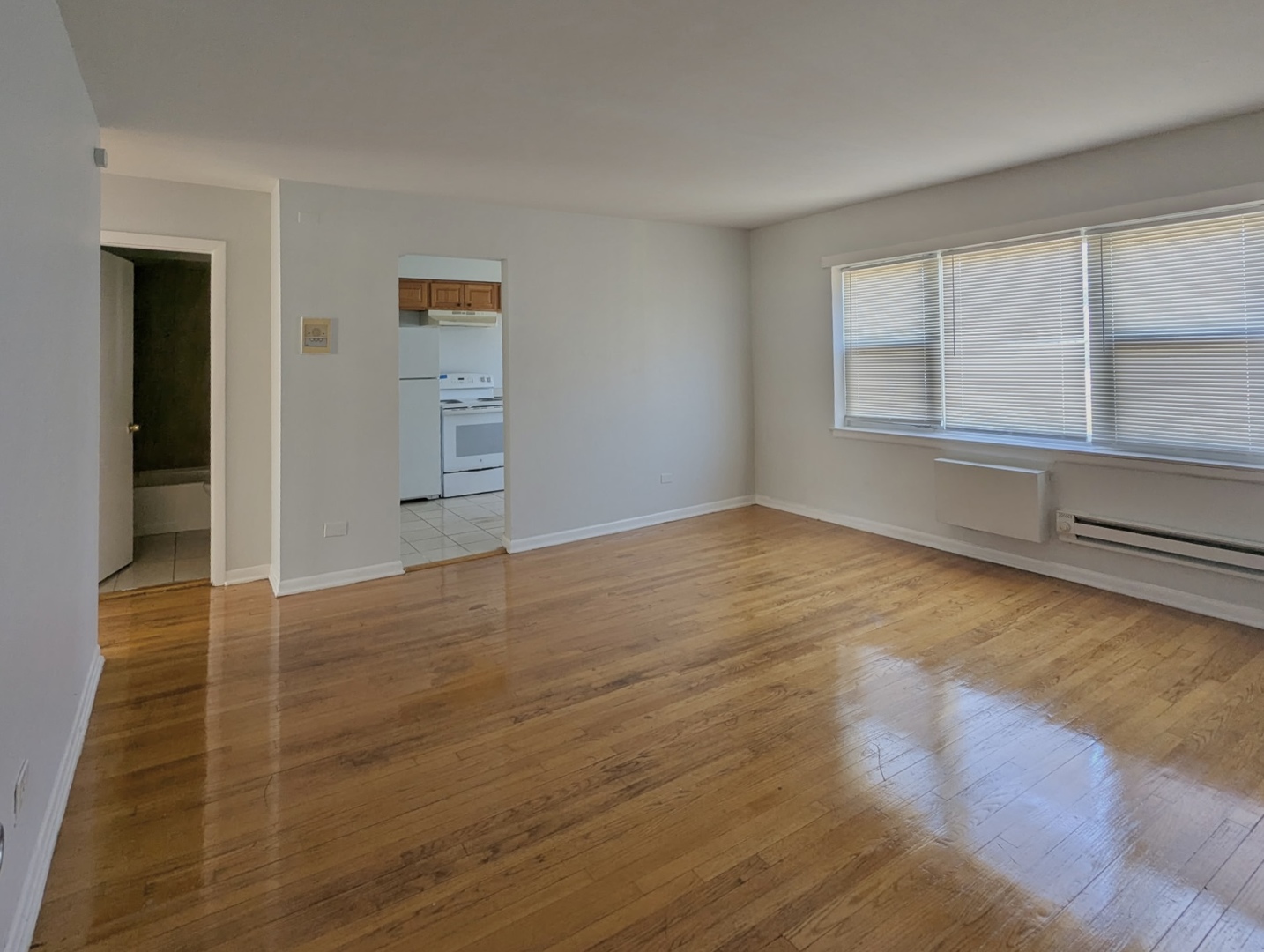 7201 South Western Avenue, Unit 72017 Chicago, IL 60636 - Photo 2 of 6 an empty room with wooden floor and windows