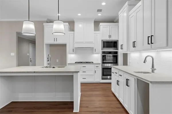 a kitchen with kitchen island a sink stainless steel appliances and cabinets