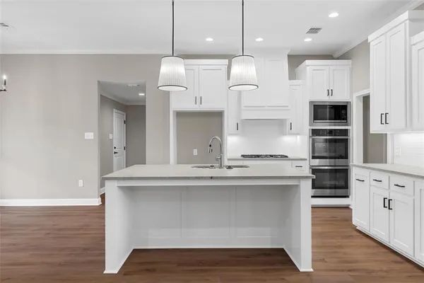 a kitchen with kitchen island white cabinets and white appliances