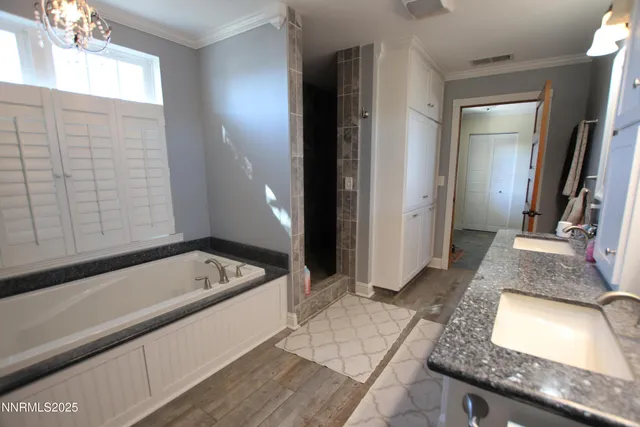 a bathroom with a granite countertop tub sink and mirror