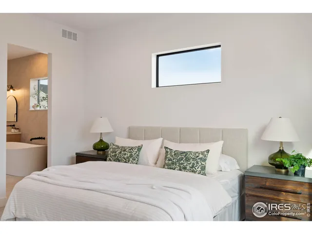 a bedroom with a bed and a potted plant