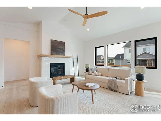 a living room with furniture a fireplace and a floor to ceiling window