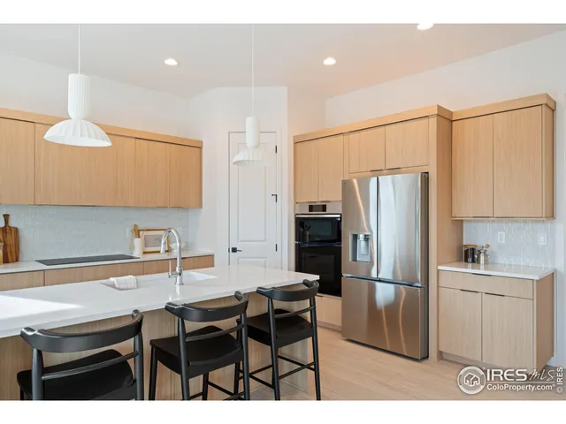 a kitchen with a table chairs refrigerator and cabinets