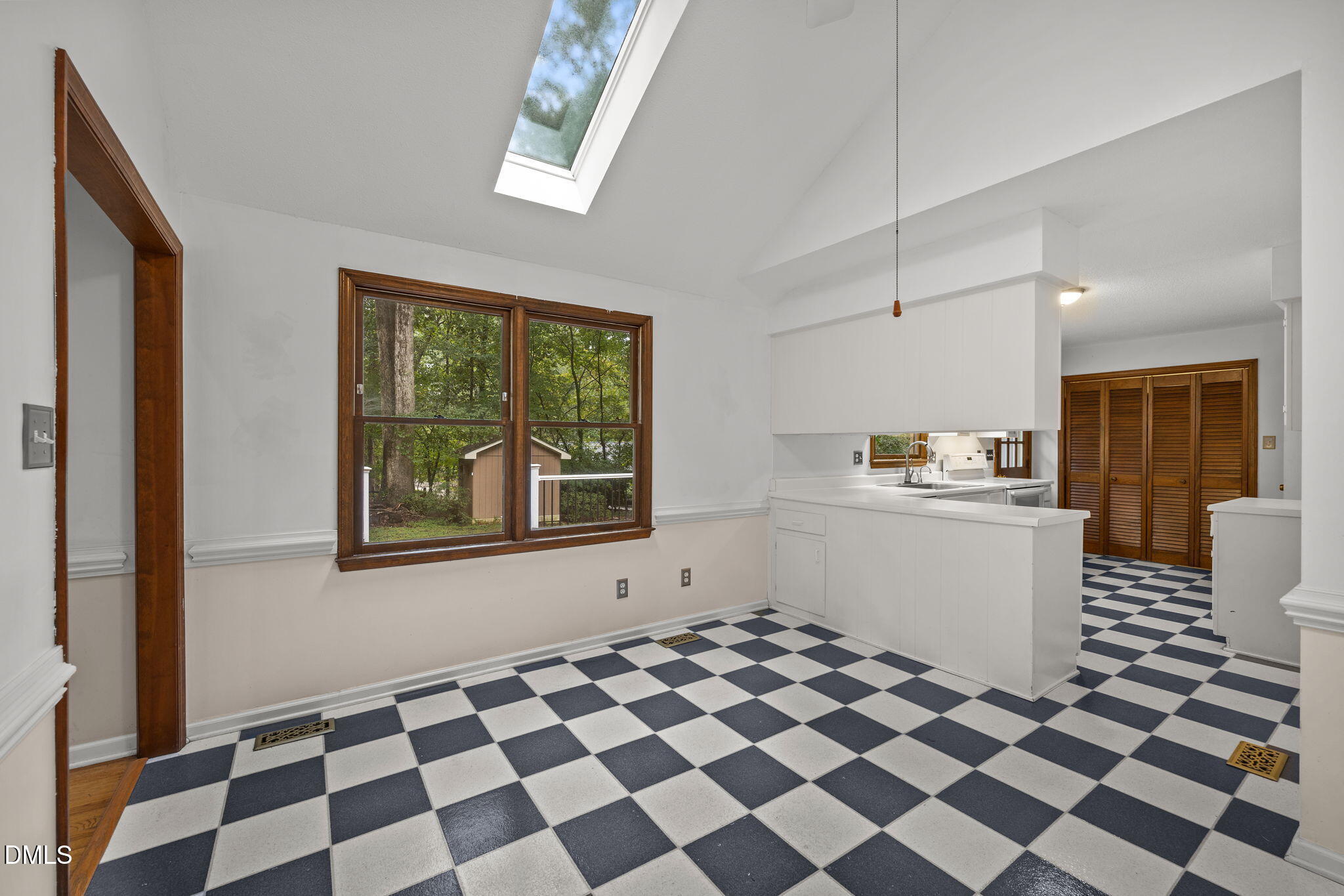 2713 Salisbury Plain Raleigh, NC 27613 - Photo 14 of 39 a kitchen with a checkered floor and white cabinets