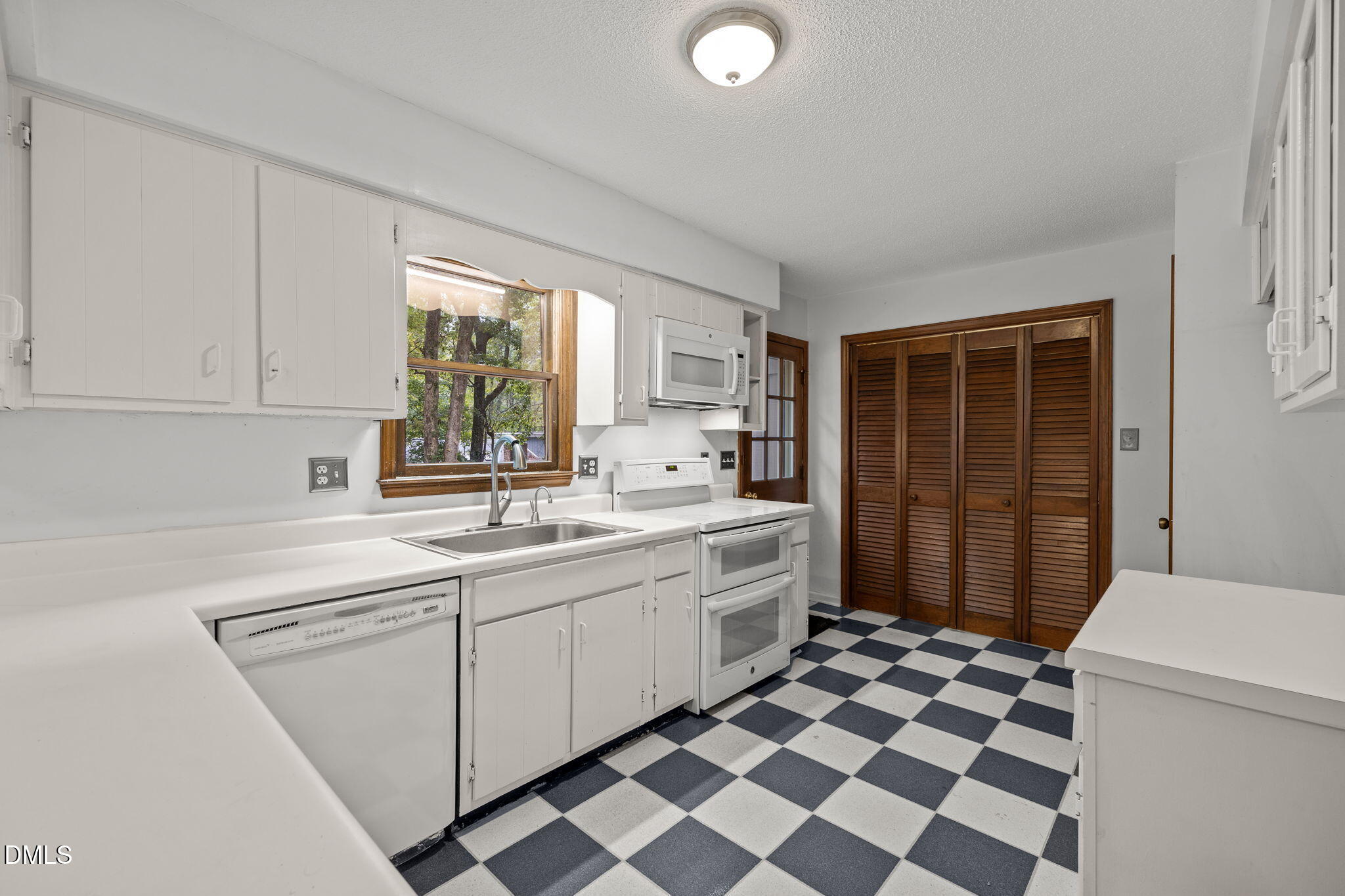 2713 Salisbury Plain Raleigh, NC 27613 - Photo 15 of 39 a kitchen with a sink a stove a refrigerator and white cabinets