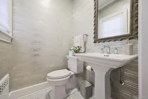 a bathroom with a sink a toilet and a mirror