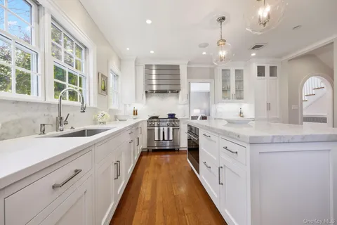 a large white kitchen with a large window