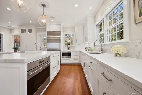 a large kitchen with stainless steel appliances kitchen island granite countertop a large counter top and a stove