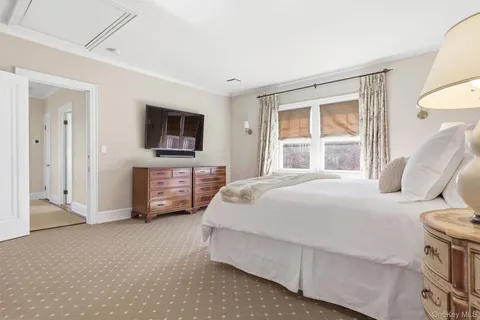a bedroom with a bed flat screen tv and a fireplace