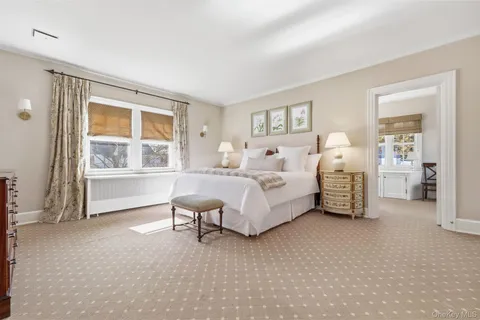 a bedroom with bed and a large window