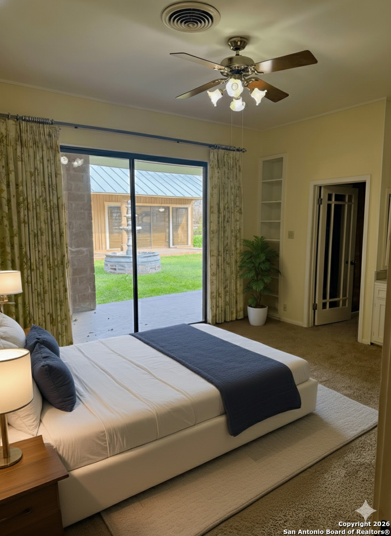 1111 Magnolia Street Uvalde, TX 78801 - Photo 19 of 34 a bedroom with a bed and a chandelier