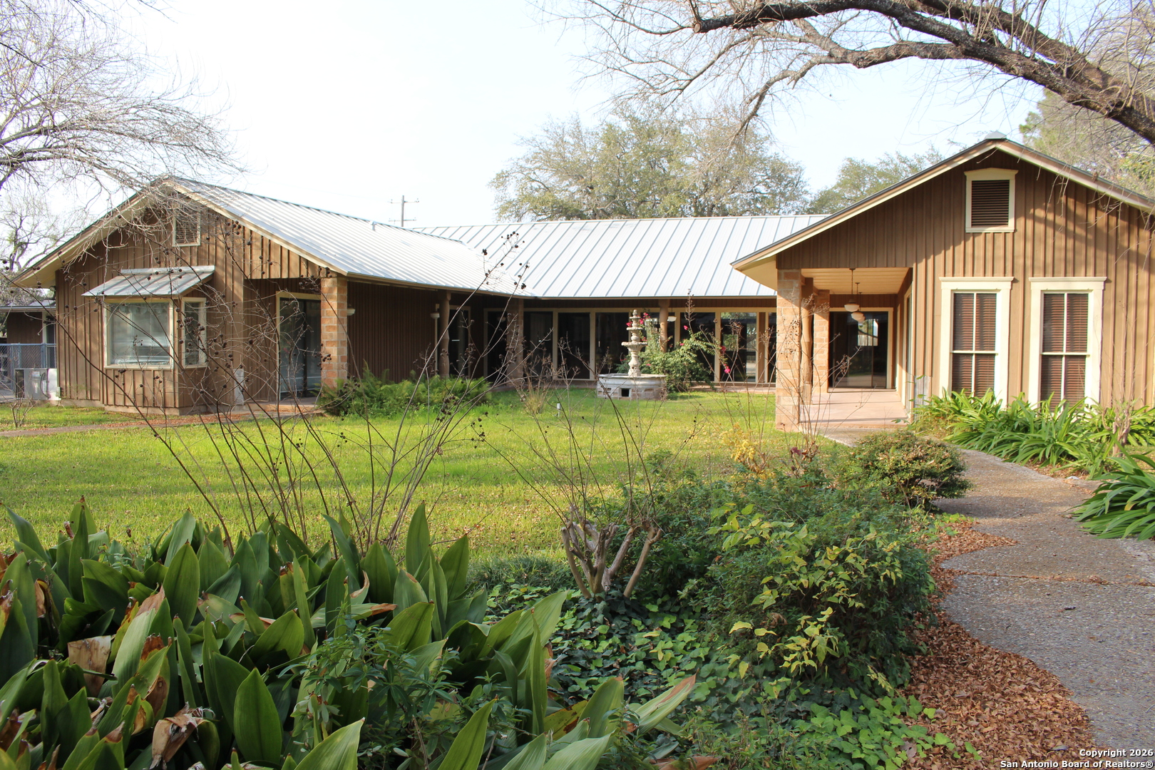 1111 Magnolia Street Uvalde, TX 78801 - Photo 26 of 34 a front view of house with yard and trees in the background