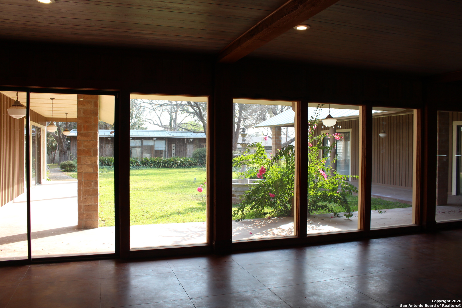 1111 Magnolia Street Uvalde, TX 78801 - Photo 7 of 34 a view of an empty room with wooden floor and a large window