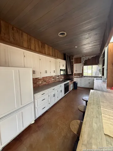a large white kitchen with cabinets