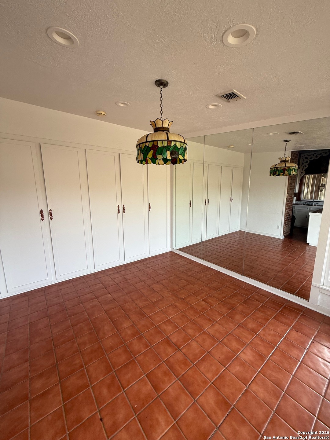 1111 Magnolia Street Uvalde, TX 78801 - Photo 10 of 34 a bedroom with a bed and a chandelier