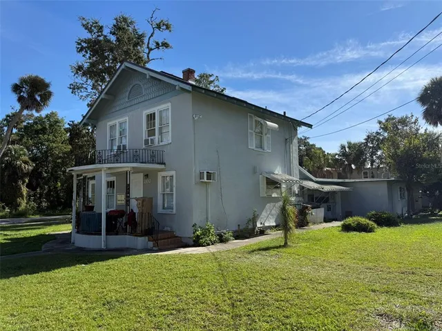 a view of a house with backyard and a tree