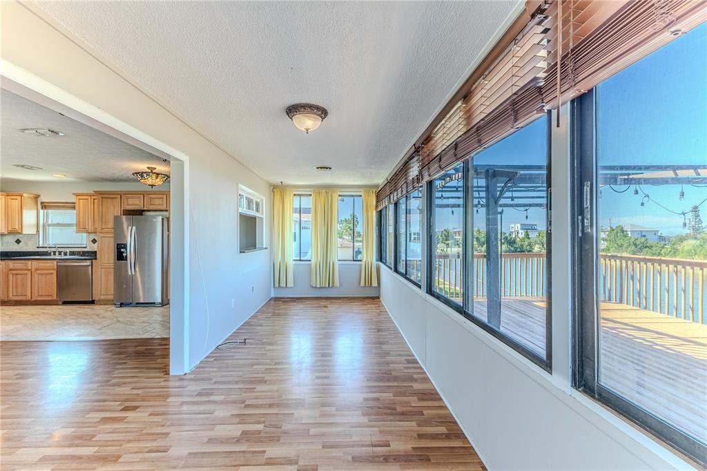 3397 Crape Myrtle Drive Hernando Beach, FL 34607 - Photo 26 of 76 a view of a hallway with wooden floor and a kitchen