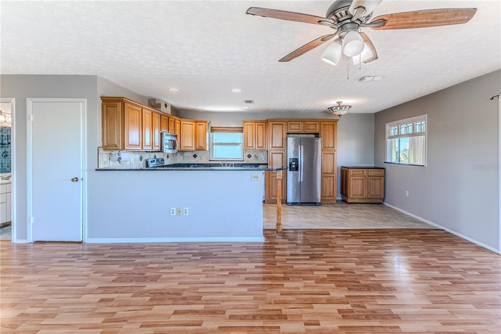 3397 Crape Myrtle Drive Hernando Beach, FL 34607 - Photo 36 of 76 a view of a kitchen with kitchen island wooden floor appliances and a window