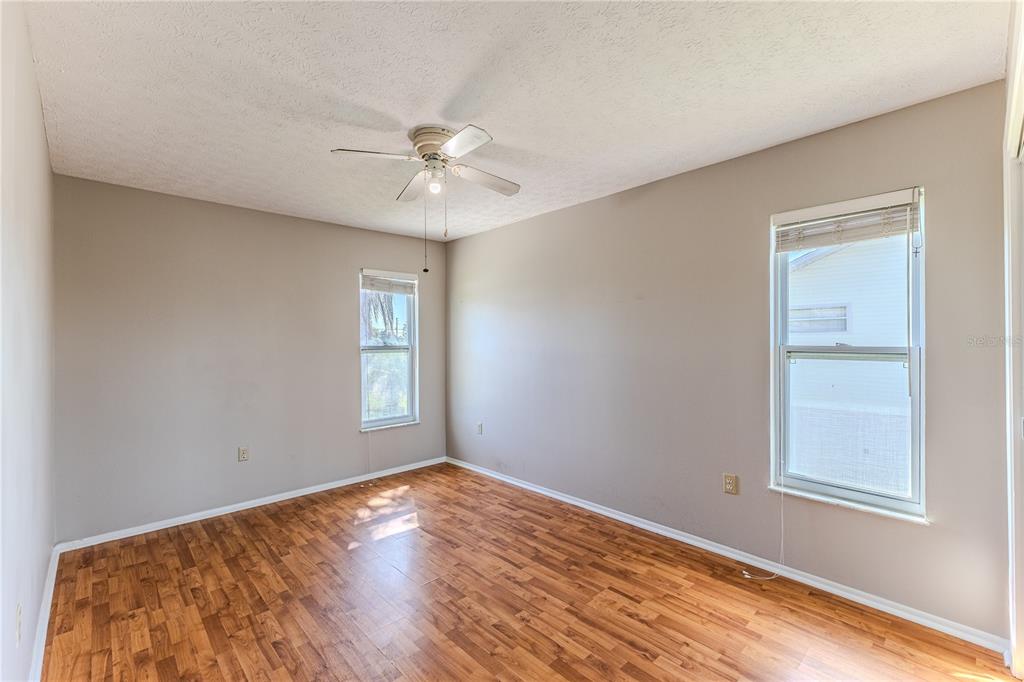 3397 Crape Myrtle Drive Hernando Beach, FL 34607 - Photo 45 of 76 a view of empty room with wooden floor and fan