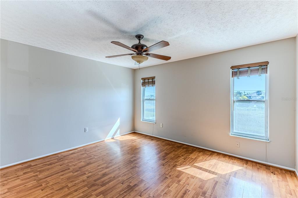 3397 Crape Myrtle Drive Hernando Beach, FL 34607 - Photo 52 of 76 a view of empty room with wooden floor and fan
