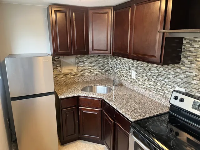 a kitchen with granite countertop stainless steel appliances and wooden cabinets