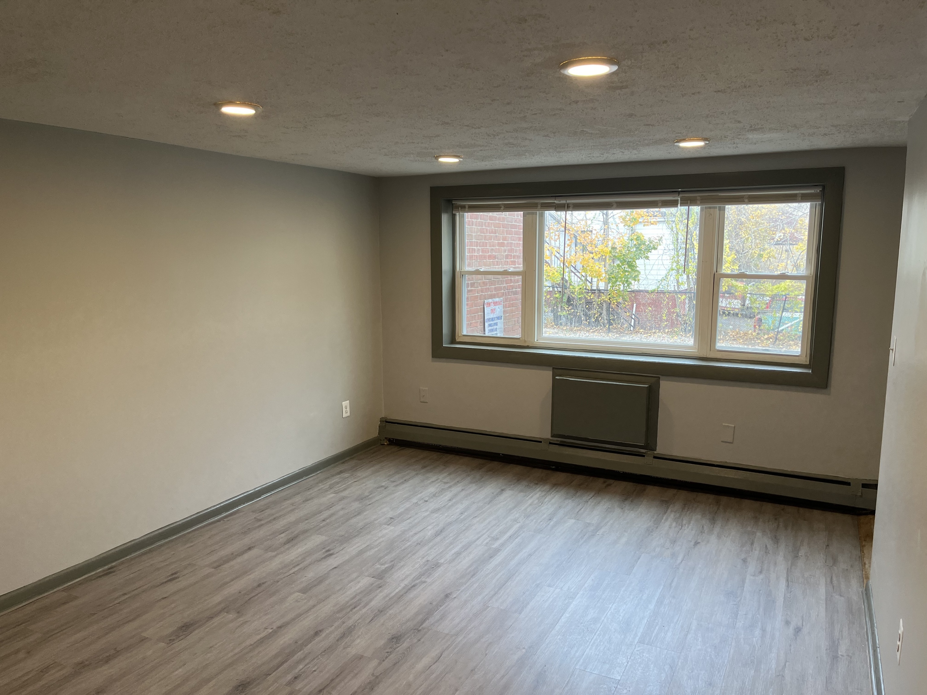 32 Cook Avenue, Unit 106 Meriden, CT 06451 - Photo 4 of 8 an empty room with wooden floor and windows