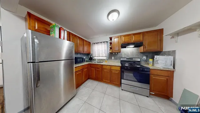 a kitchen with stainless steel appliances granite countertop a refrigerator and a stove