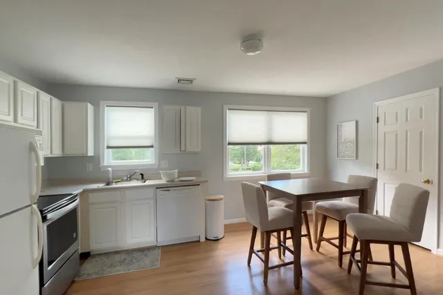 a room with a bed and a view of living room