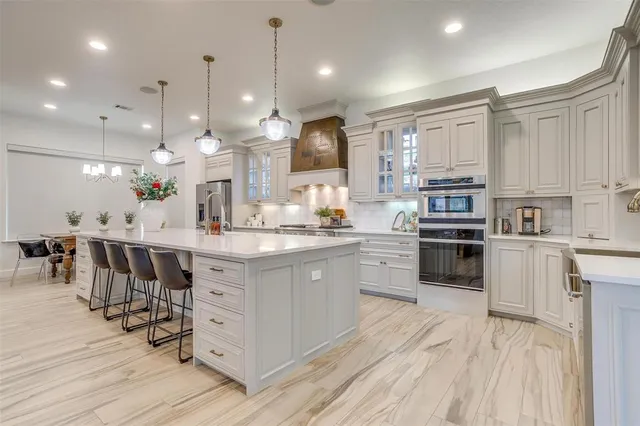a kitchen with kitchen island granite countertop lots of wooden cabinets a sink appliances and a center island