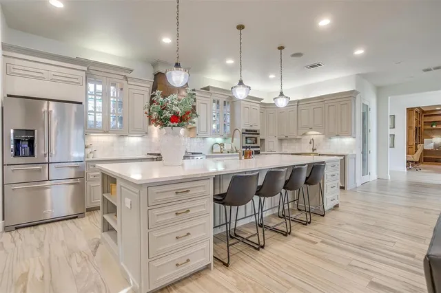 a kitchen with kitchen island granite countertop a sink cabinets and wooden floor