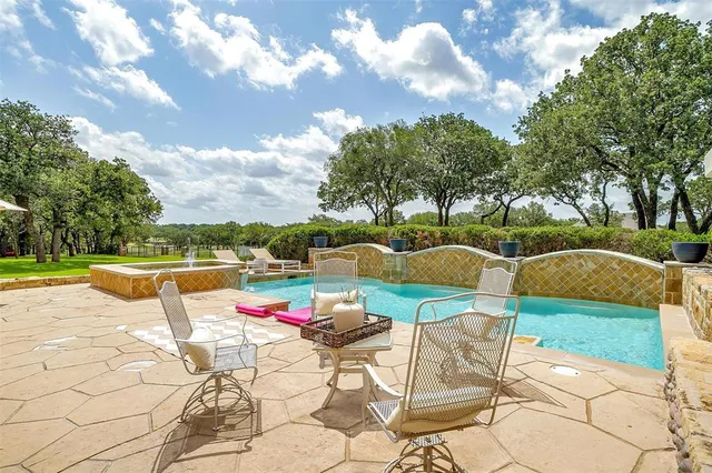 a view of swimming pool with table and chairs