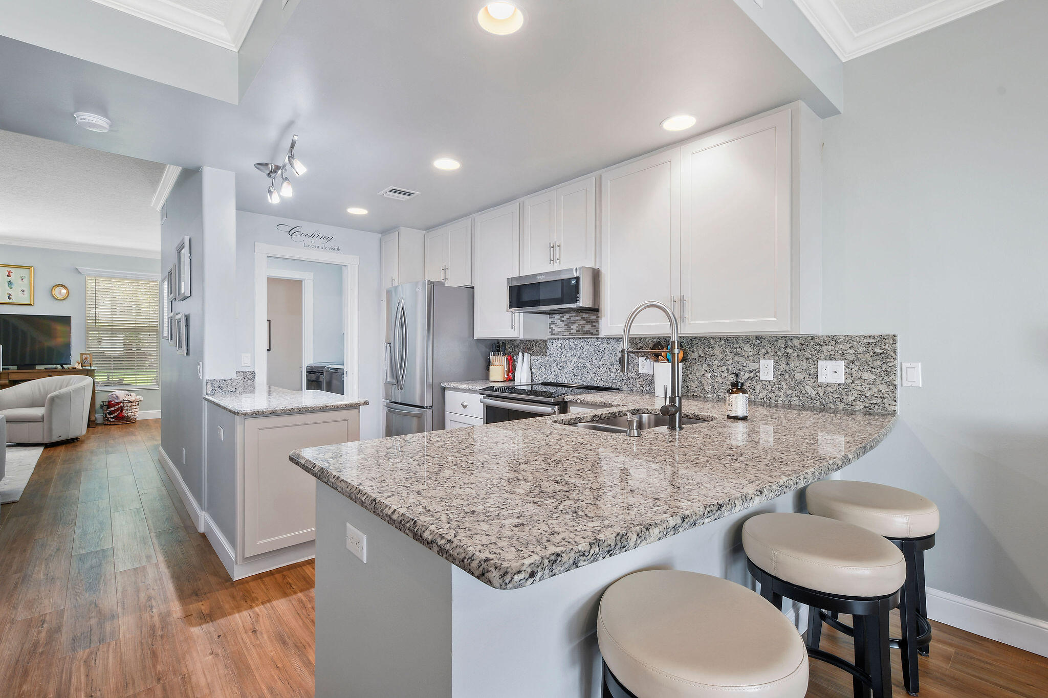 111 Ashley Court Jupiter, FL 33458 - Photo 12 of 68 a kitchen with granite countertop kitchen island stainless steel appliances a sink and a refrigerator